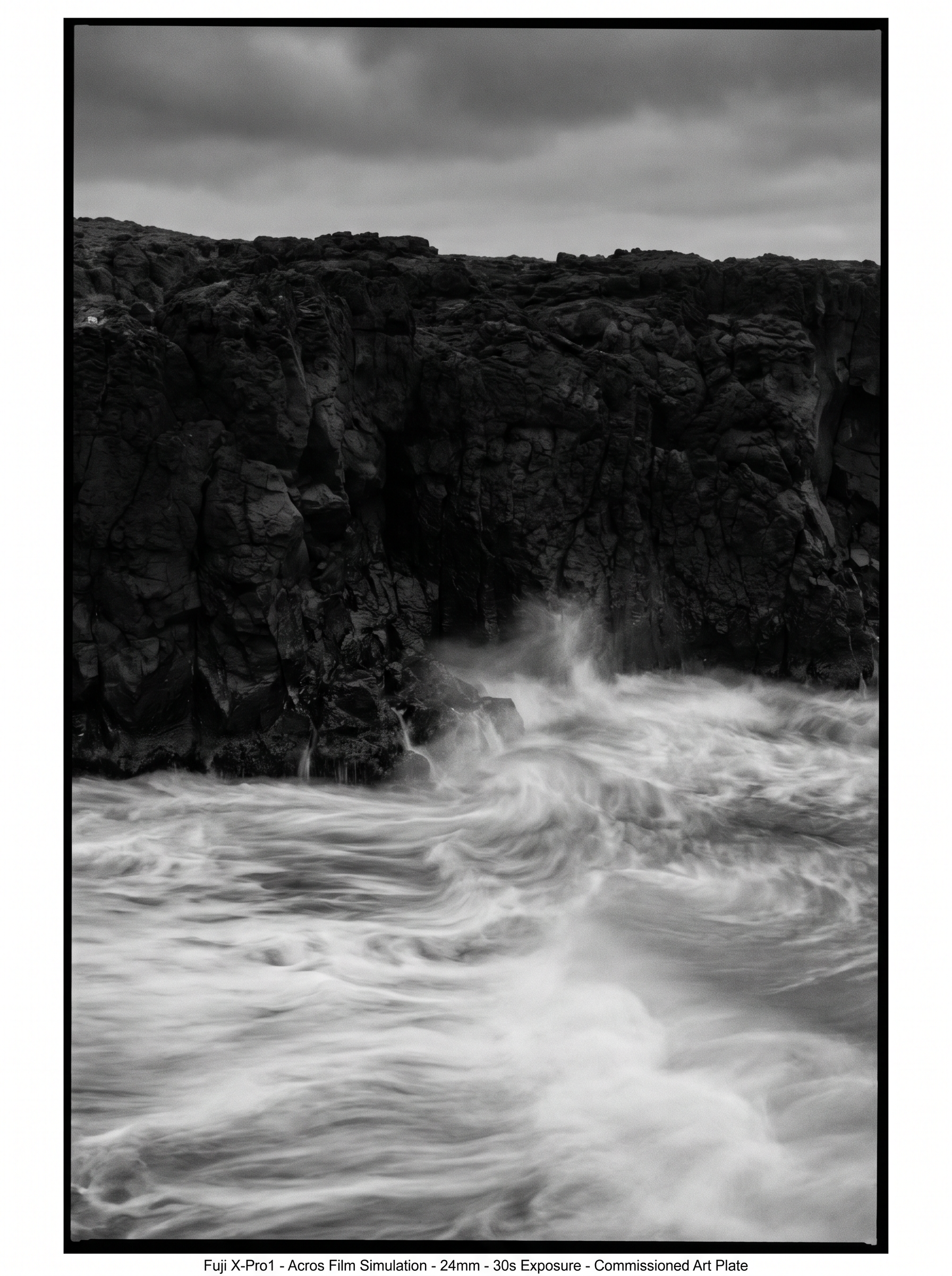 Coastal cliff at the waterline. 30-second exposure. Rock is eternal and sharp. Ocean is silk and continuous. Mist rises at the contact point. Fuji X-Pro1 aesthetic, Michael Kenna and Hiroshi Sugimoto lineage.